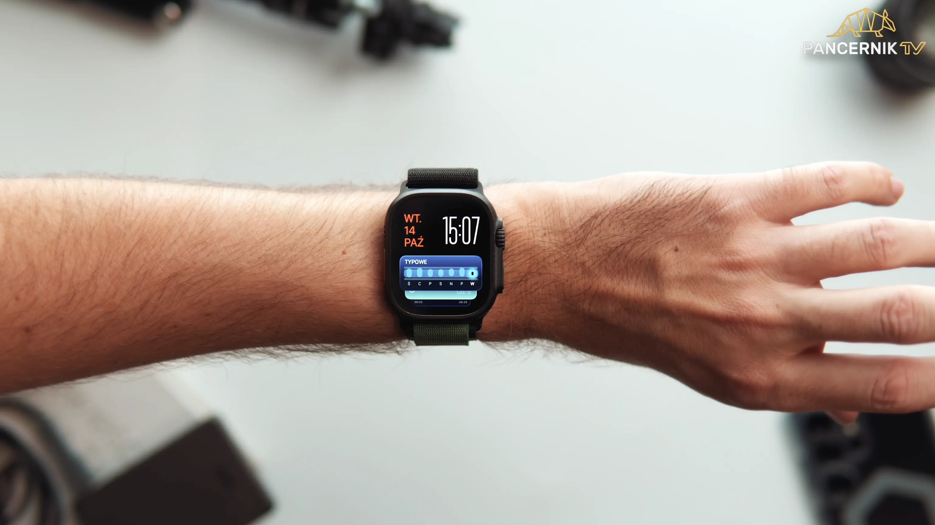 Mężczyzna sprawdzający powiadomienia i kalendarz na ekranie zegarka Apple Watch Ultra.