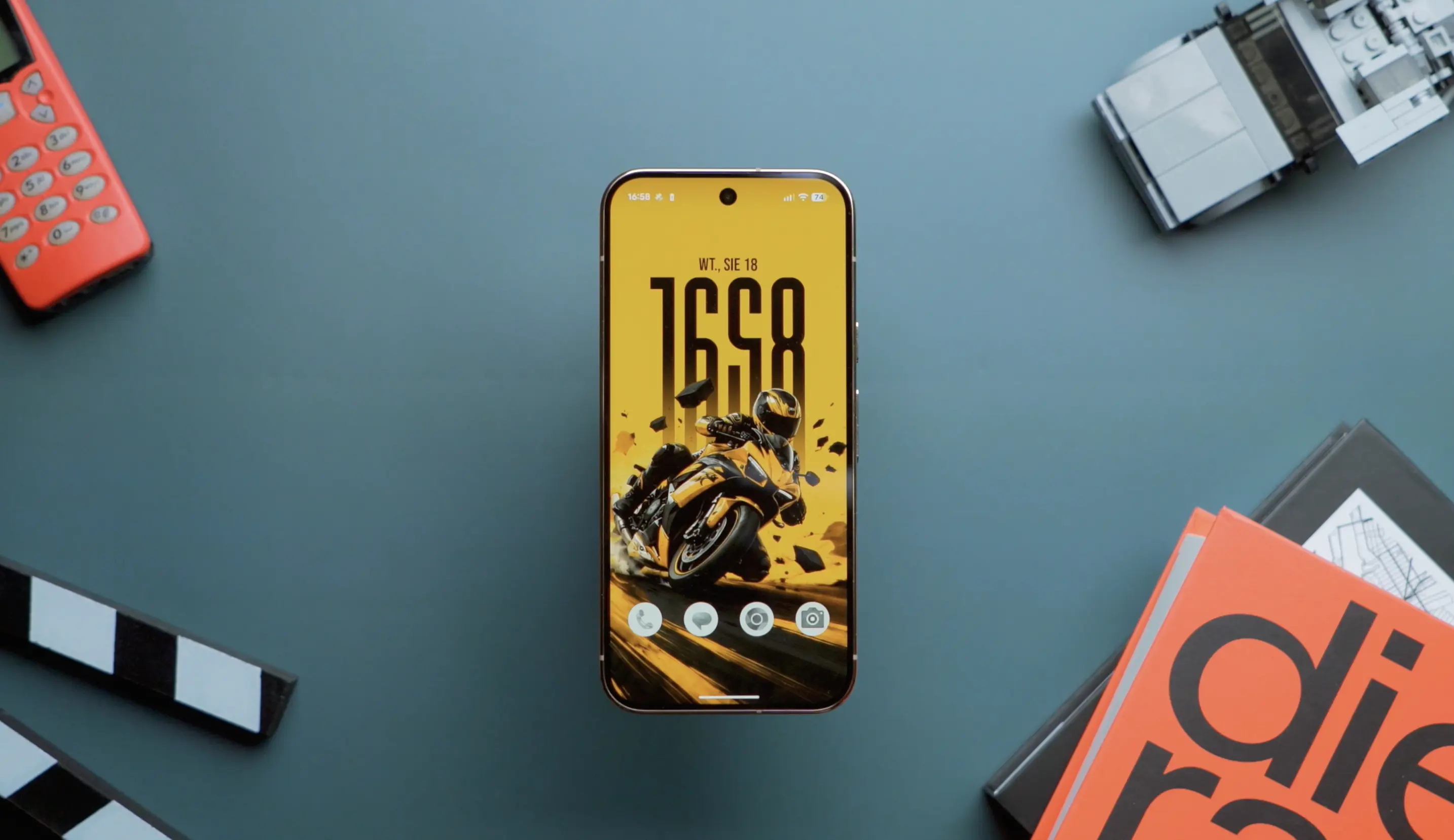 Smartfon Google Pixel spoczywający na stole i przedstawiający interfejs ekranu głównego na Android 17.