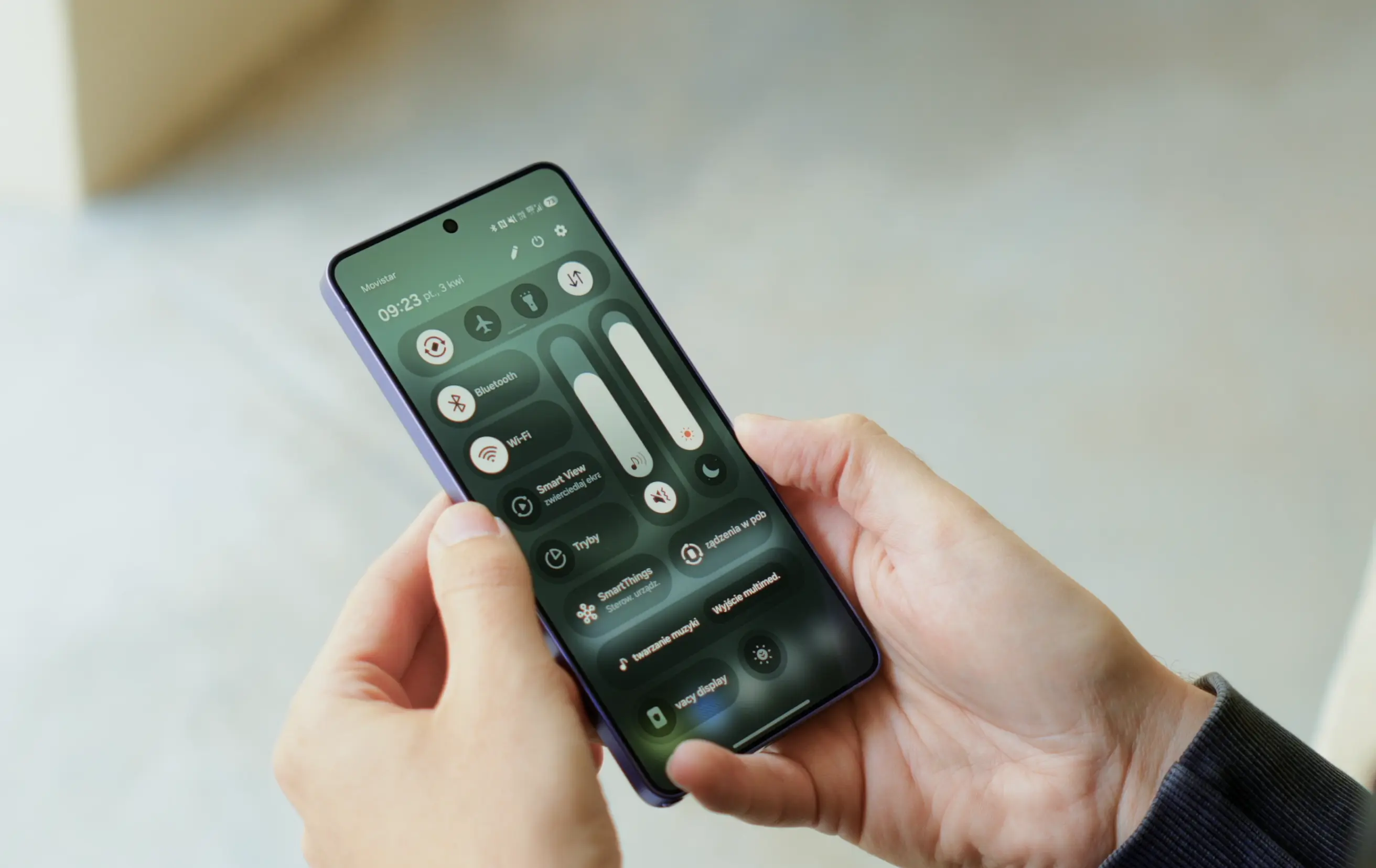 Smartfon Samsung Galaxy z wyświetlonym menu ustawień systemowych One UI na ekranie.