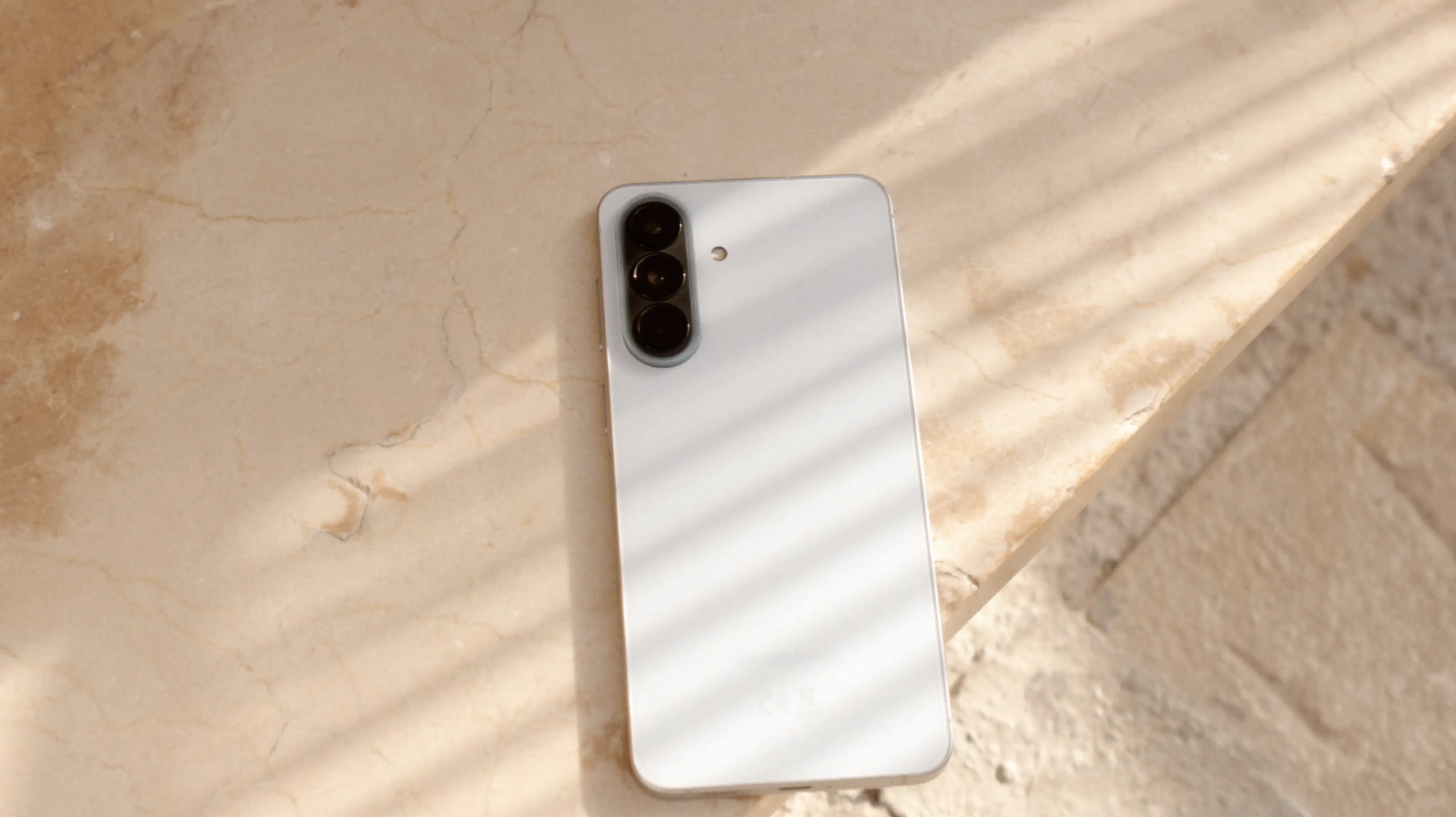 Samsung A57 spoczywający na ziemi w promieniach wschodzącego słońca